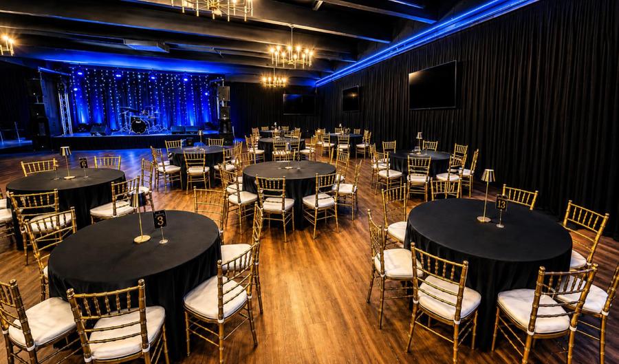 The hall set with round banquet tables for a celebration